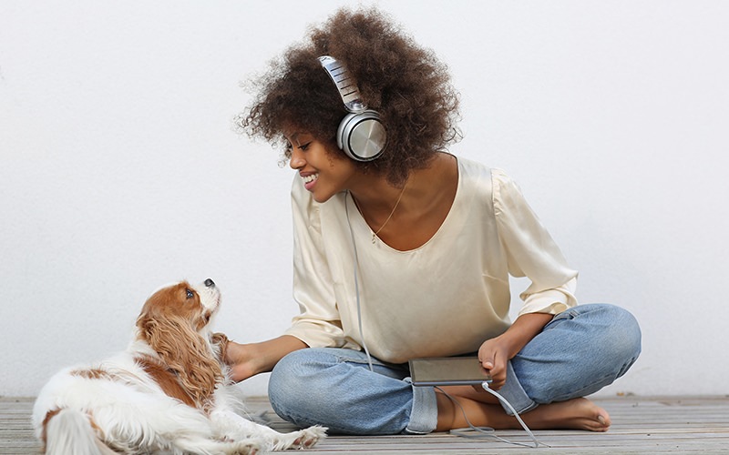Woman sitting with her dog listening to music