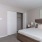 Spacious and well lit bedroom with plush carpet and large windows