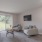 Spacious and well lit living room with wood floors and an open floor plan with access to the kitchen.