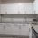 Spacious and well lit kitchen with wood floors and stainless steel appliances. 