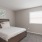 Spacious and well lit bedroom with plush carpet and large windows