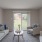 Spacious and well lit living room with wood floors and an open floor plan with access to the kitchen.
